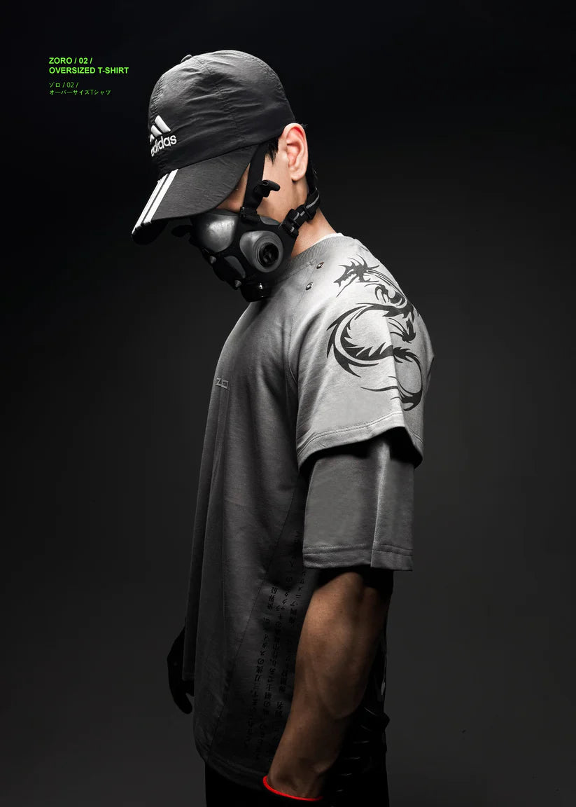 Person wearing a gas mask and gray t-shirt with a tattoo on a black background