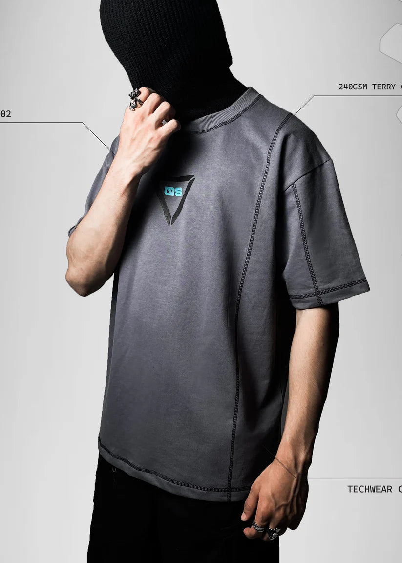 Person wearing a gray t-shirt with a logo on a light gray background