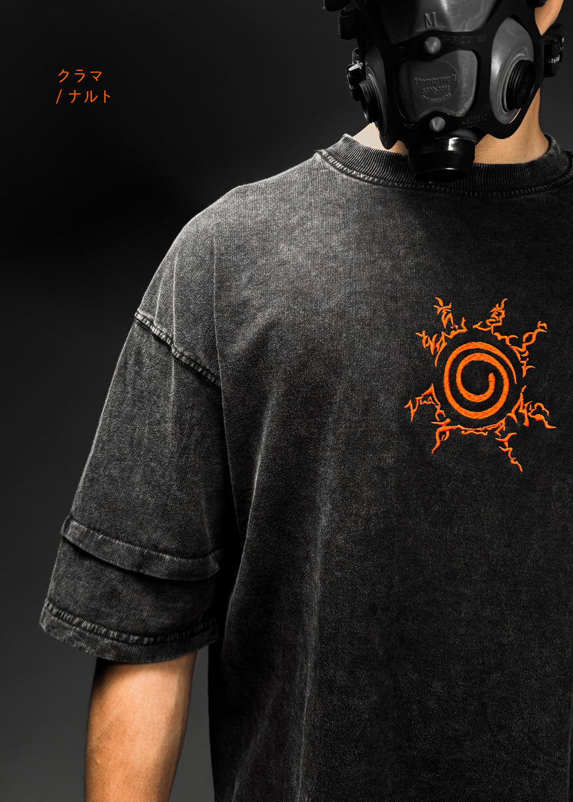 Person wearing a black t-shirt with an orange symbol and a gas mask on a dark background