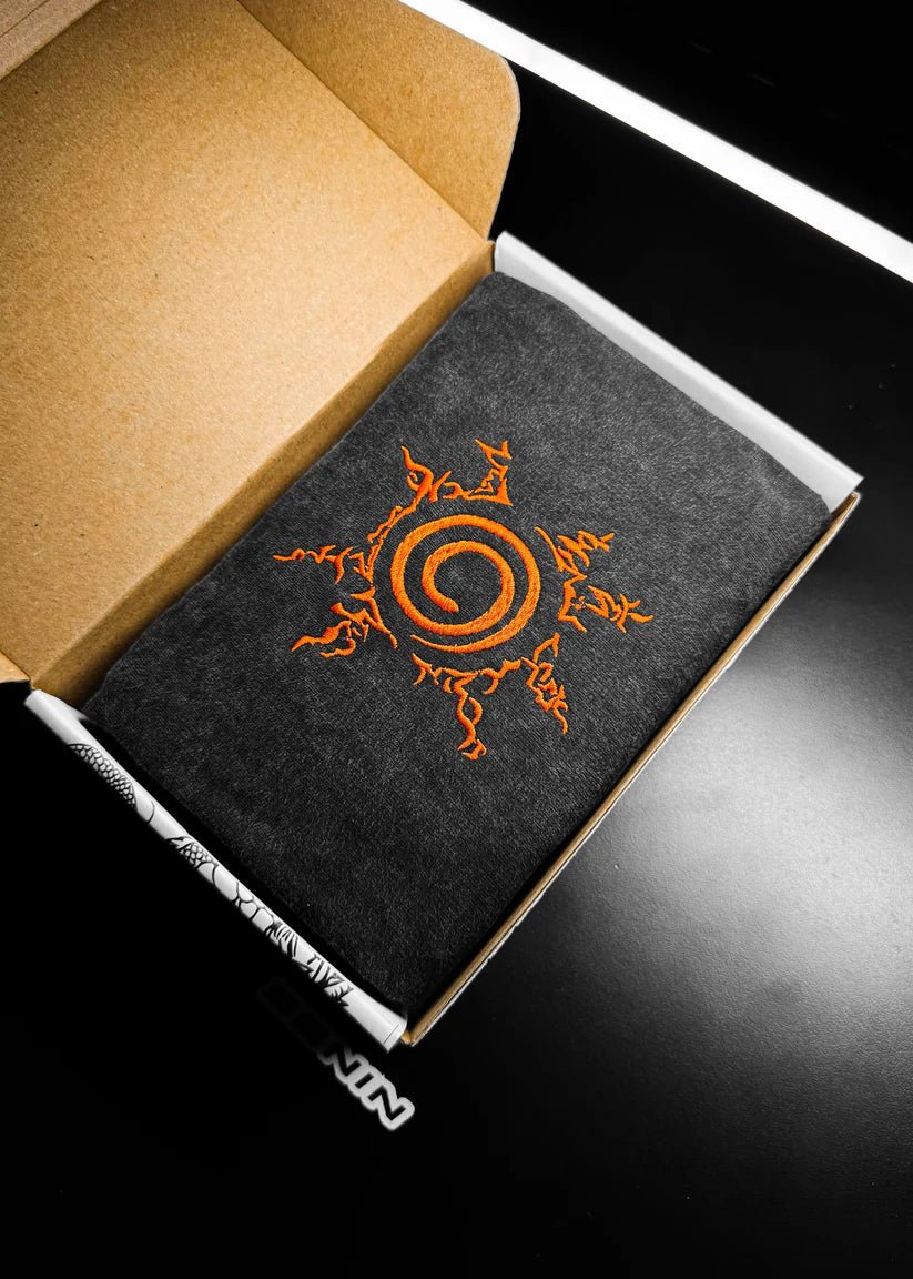 Black notebook with orange design on a black surface
